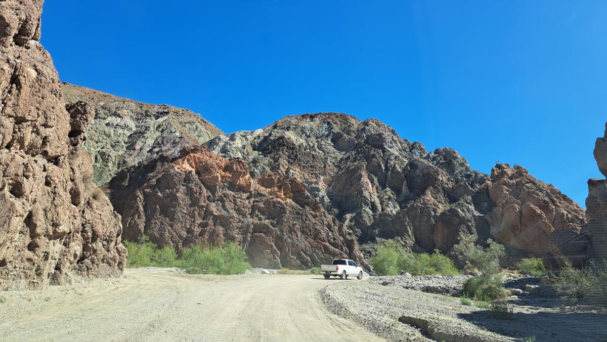 Une camionnette roule sur un chemin de terre dans un canyon.