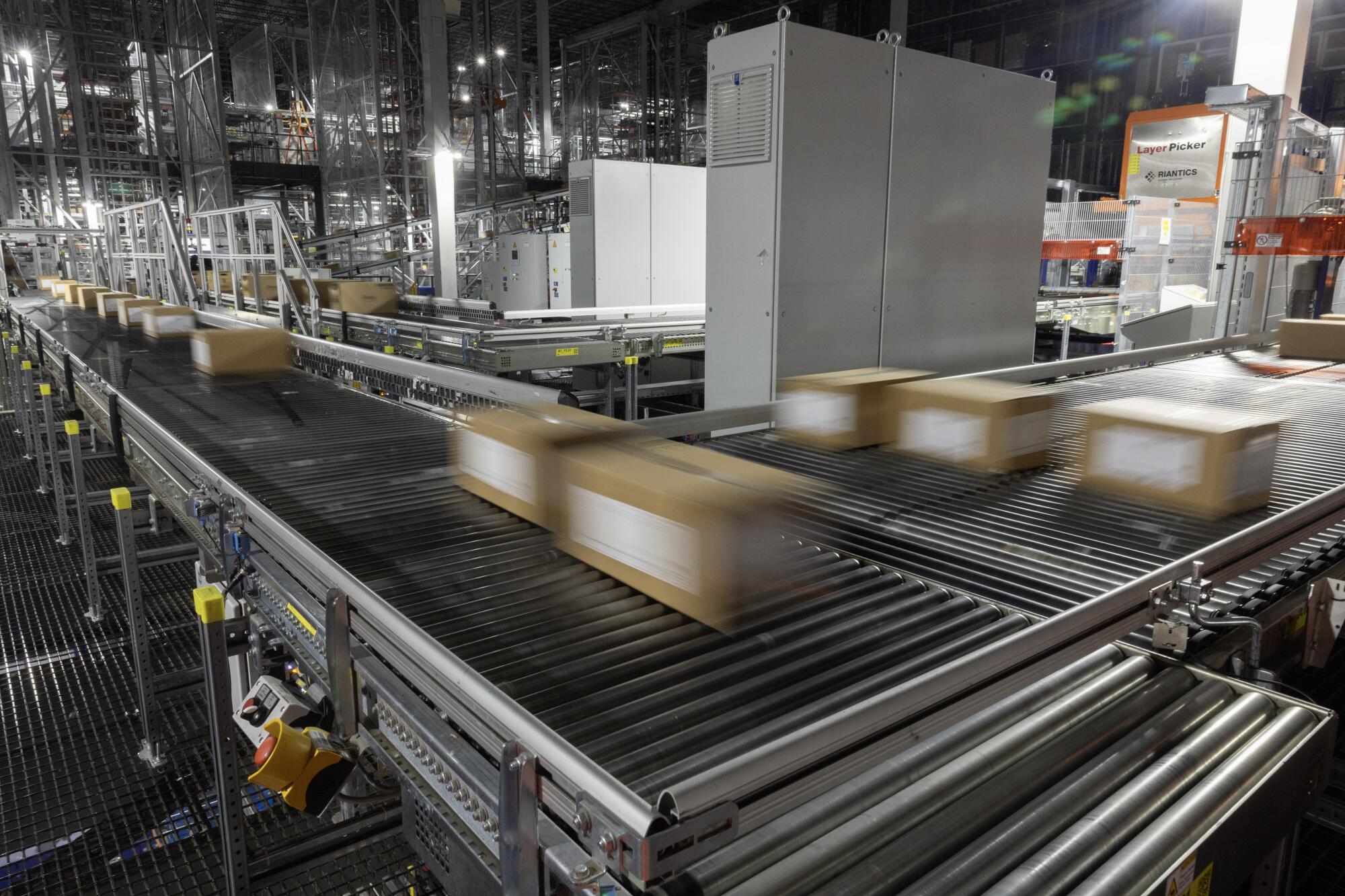 Les marchandises en boîte se déplacent le long d'un tapis roulant dans un entrepôt. 
