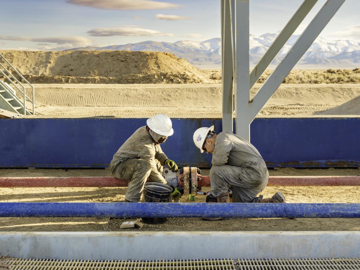 Deux ouvriers installent une canalisation sur le site Project Red de Fervo Energy, dans le nord du Nevada.