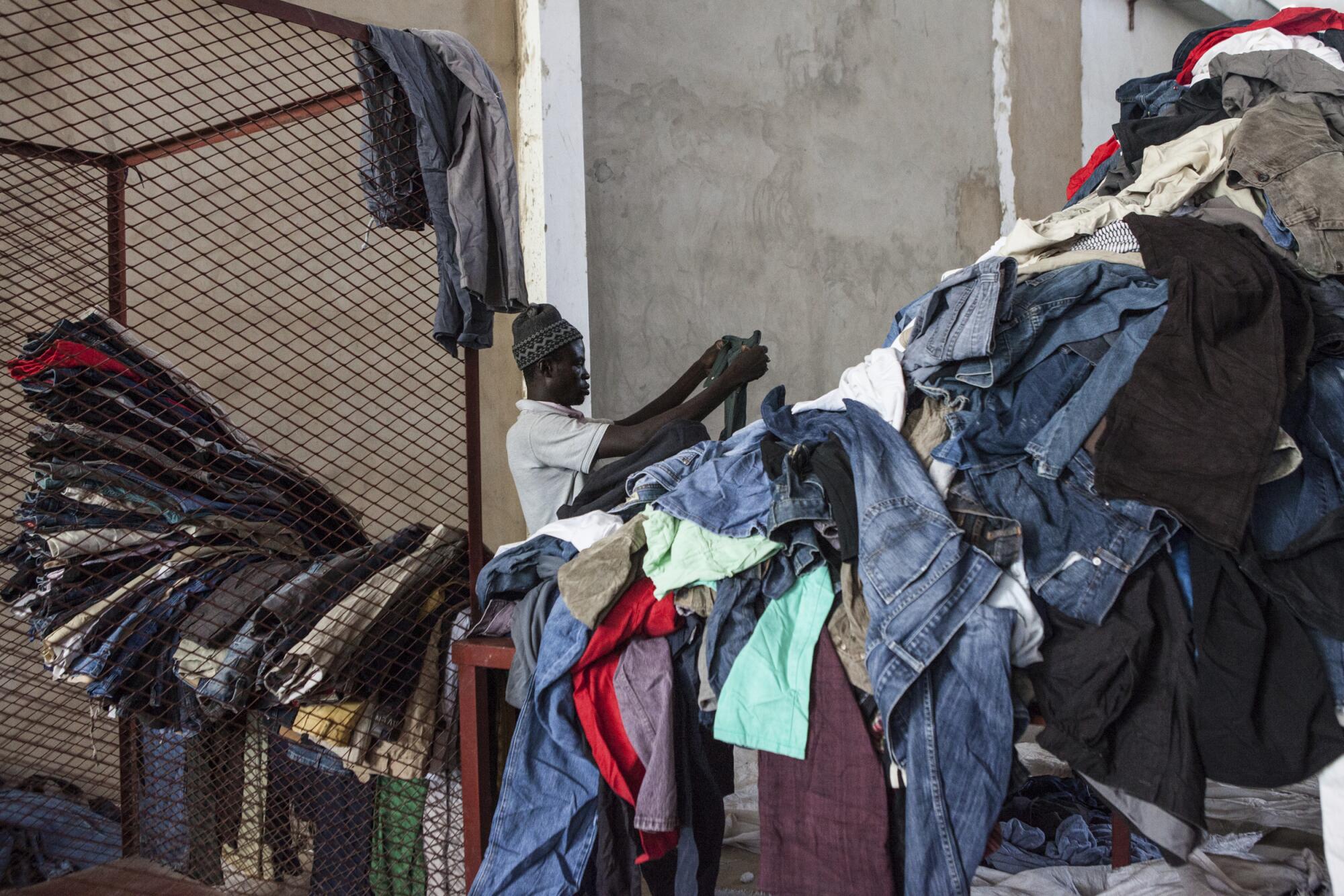 Une personne trie une pile de vêtements.