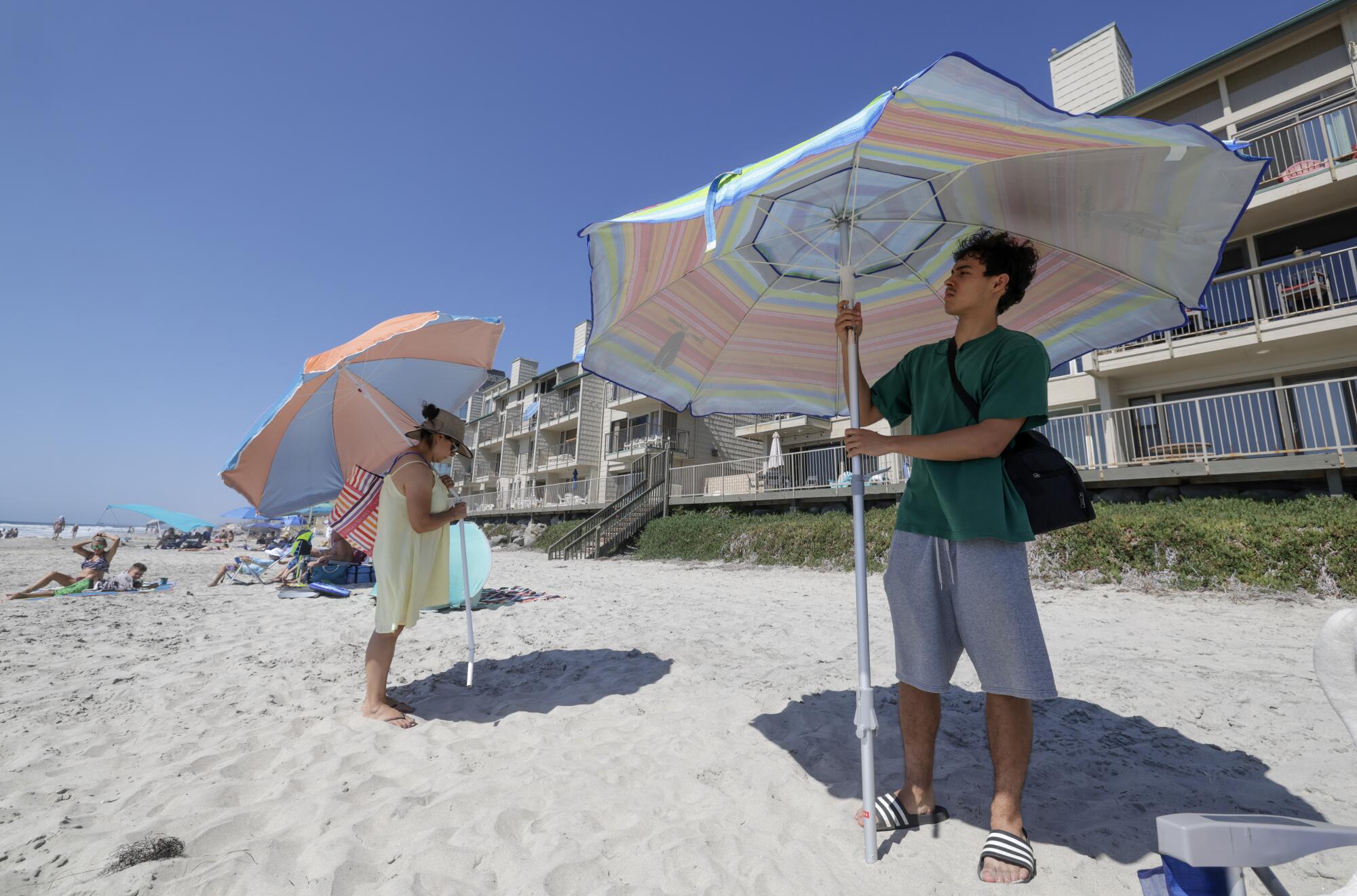 Les résidents d'Escondido, Rosa Anguiano et son fils Christopher Rivera, 17 ans, ont installé des parasols sur la plage de Carlsbad.