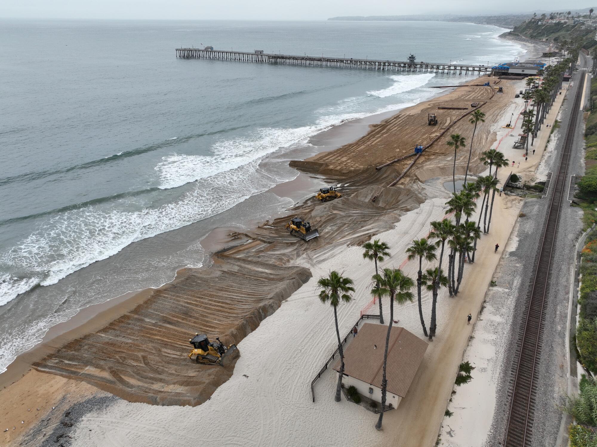 Des ouvriers reconstituent la plage avec du sable neuf au sud de la jetée de San Clemente.