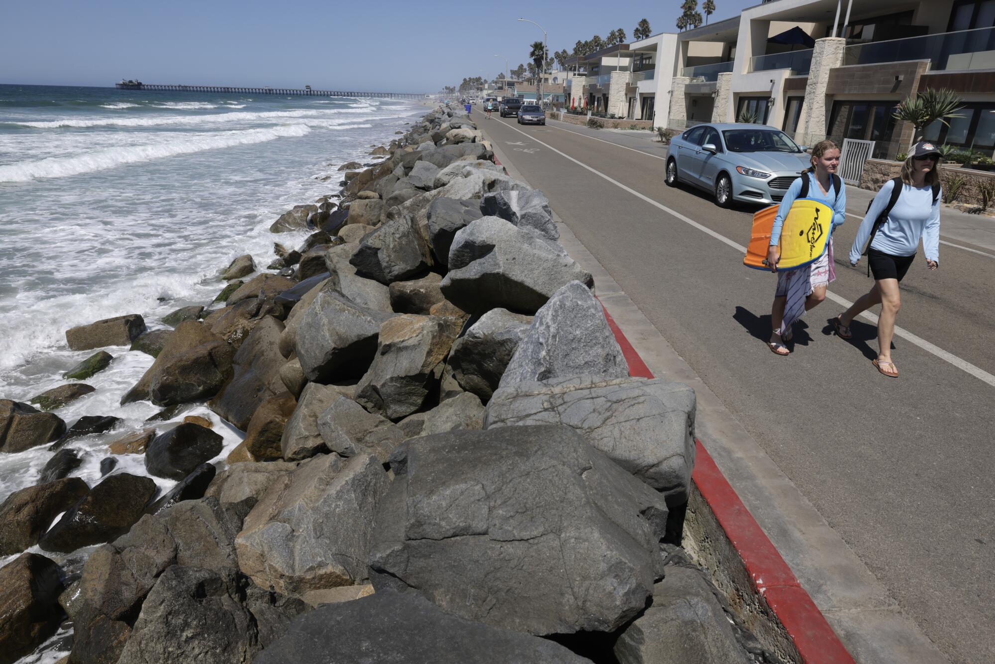 Les gens marchent le long de l'extrémité sud du Strand à Oceanside.