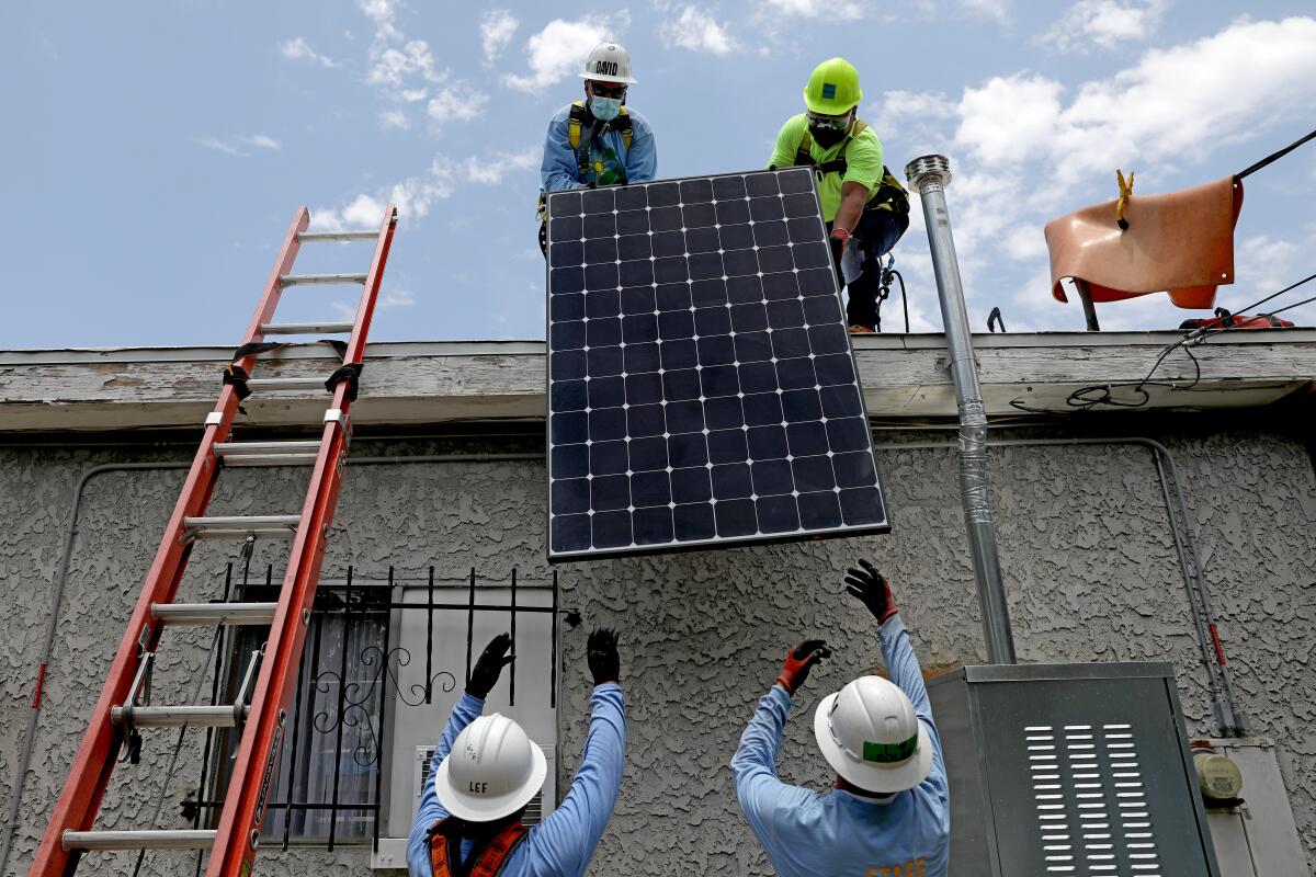 Les ouvriers installent des panneaux solaires sur le toit