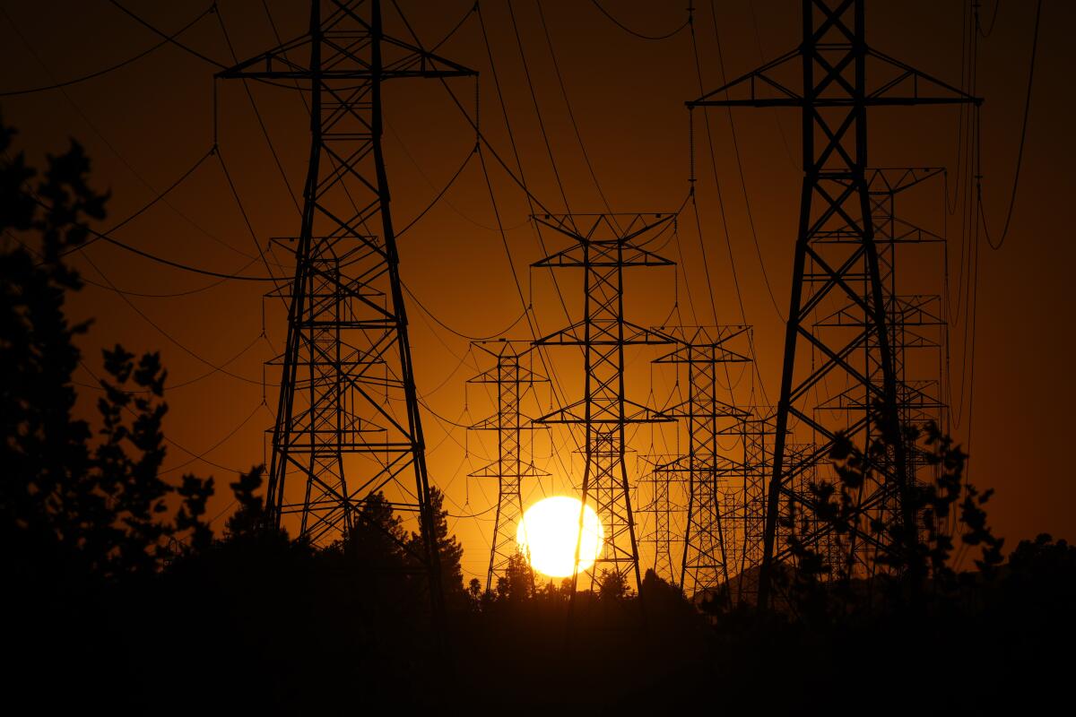 Le soleil se couche derrière les lignes électriques dans la vallée de San Fernando.