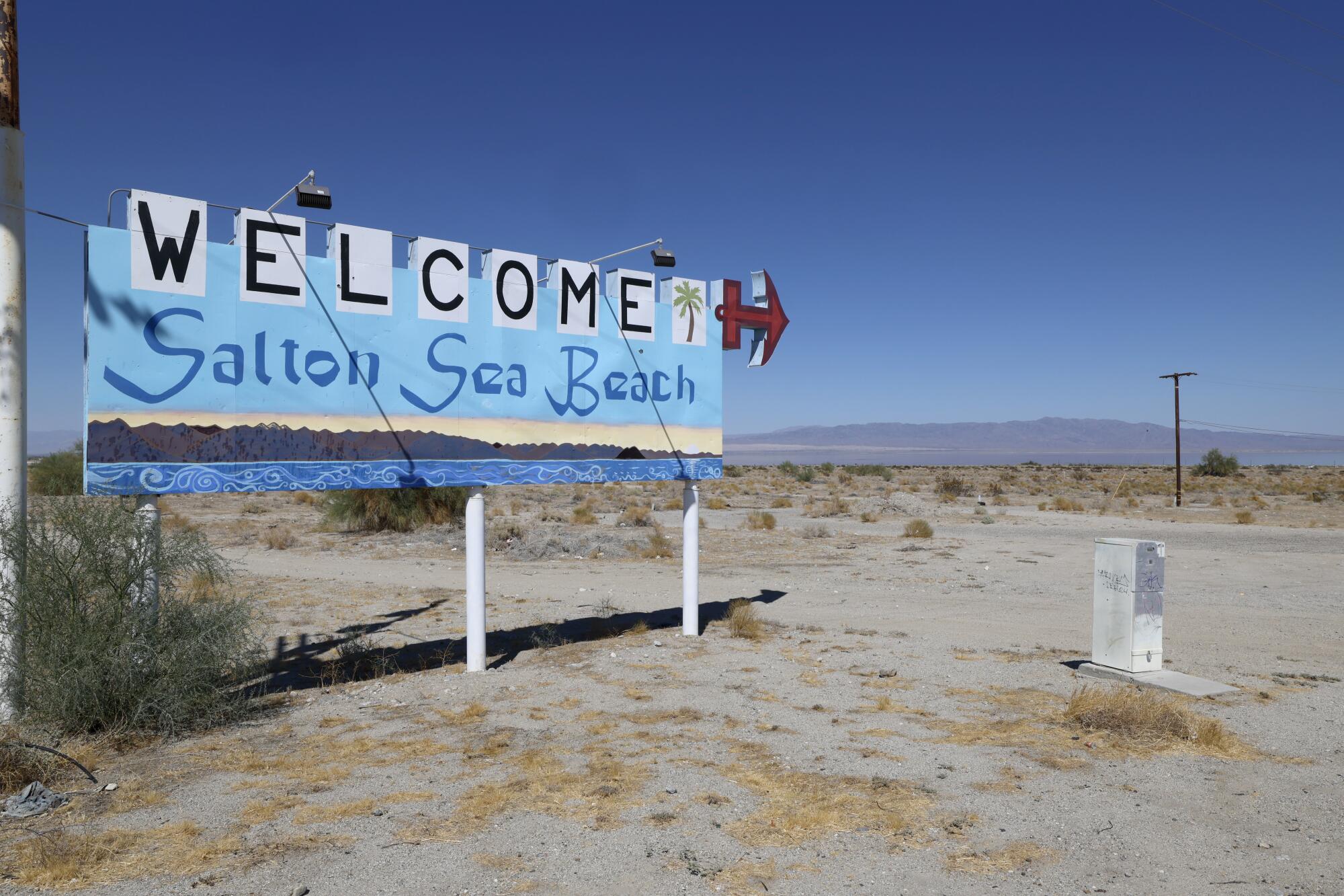 Un panneau de bienvenue se dresse à l’entrée de Desert Shores, à côté de la mer de Salton qui rétrécit.