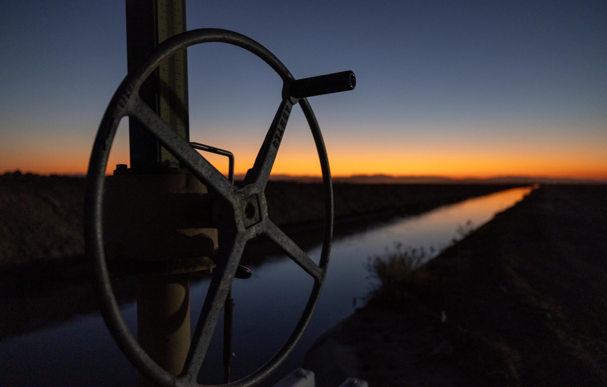 Une porte d'écoulement d'eau et un canal d'irrigation au crépuscule dans la vallée impériale. 