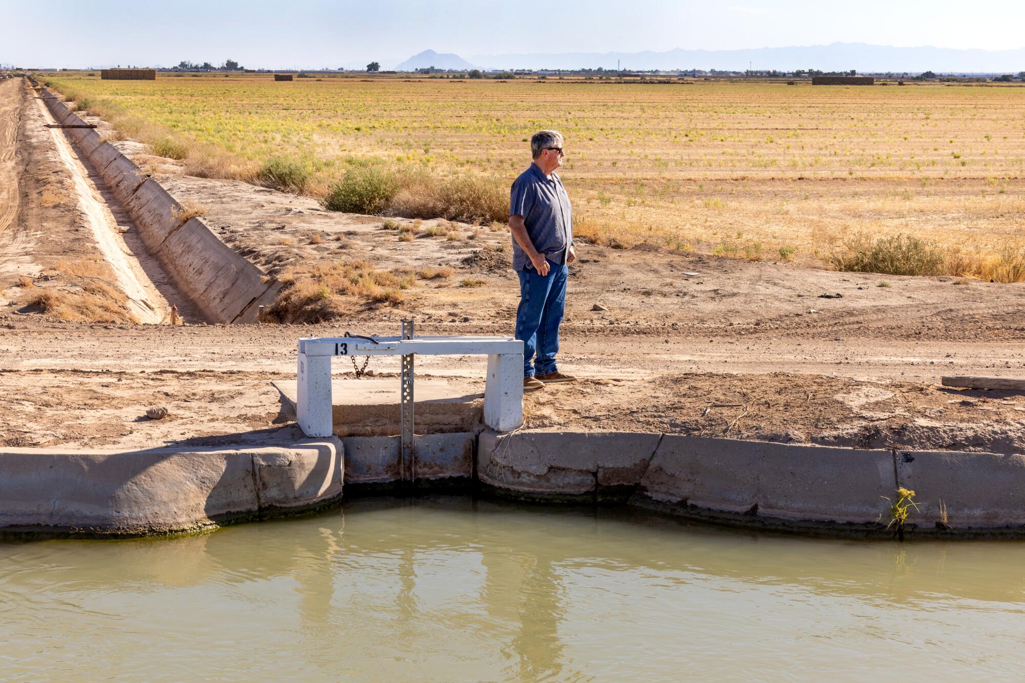 Mark McBroom se tient à côté d'une porte de canal verrouillée par le district impérial d'irrigation.