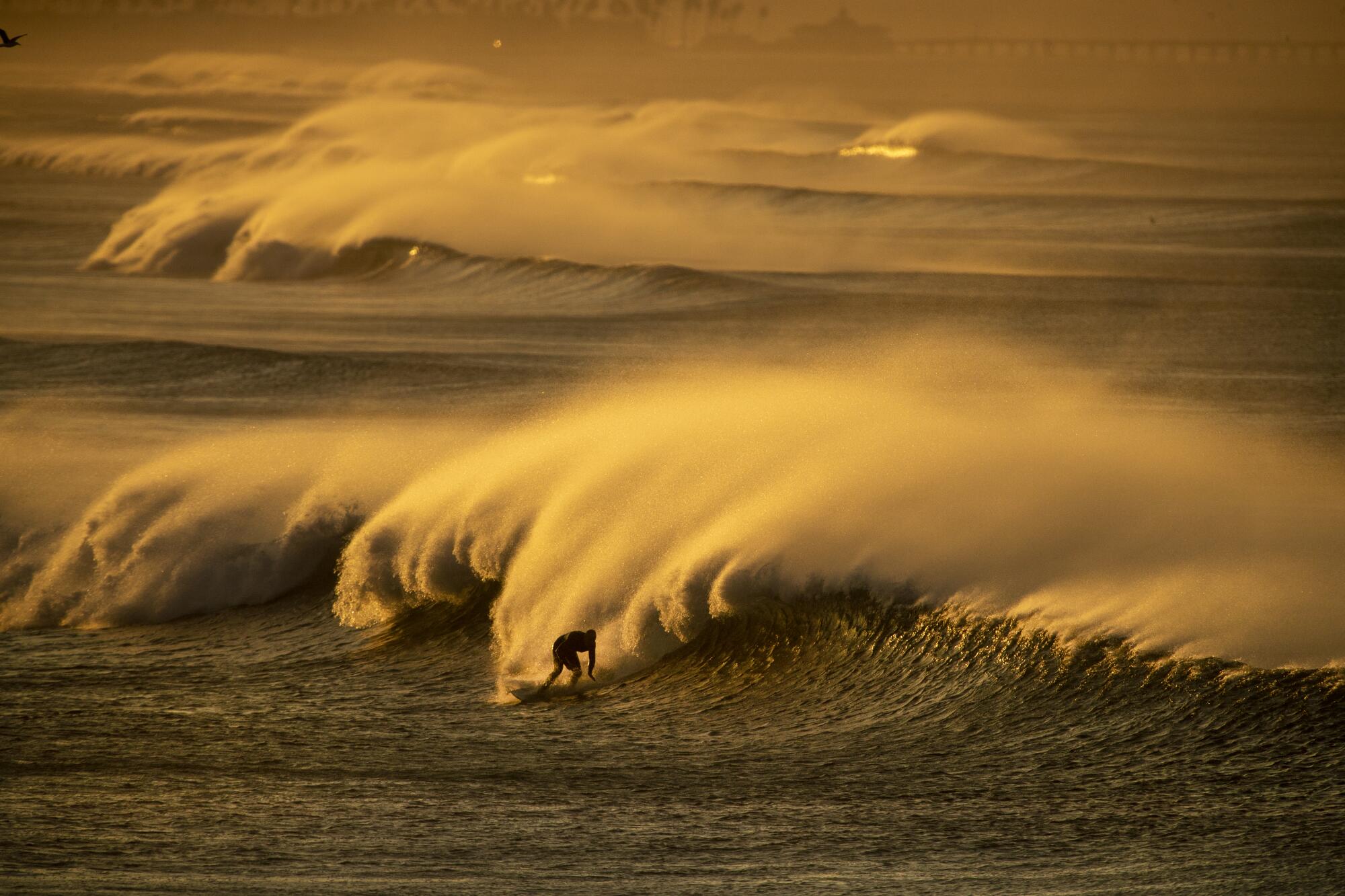Les vents forts de Santa Ana projettent des embruns provenant des vagues au large d'une plage.