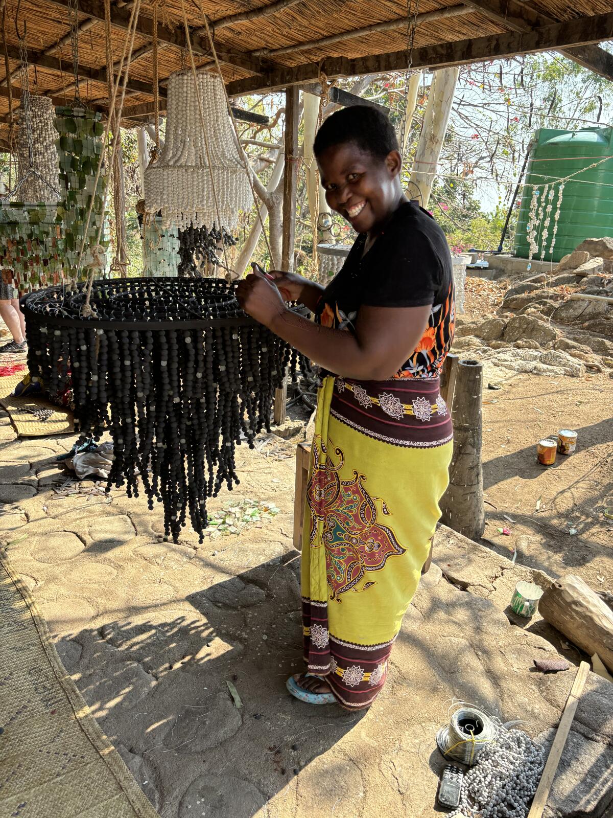 Une femme expose un lustre fait de boules d’argile. 