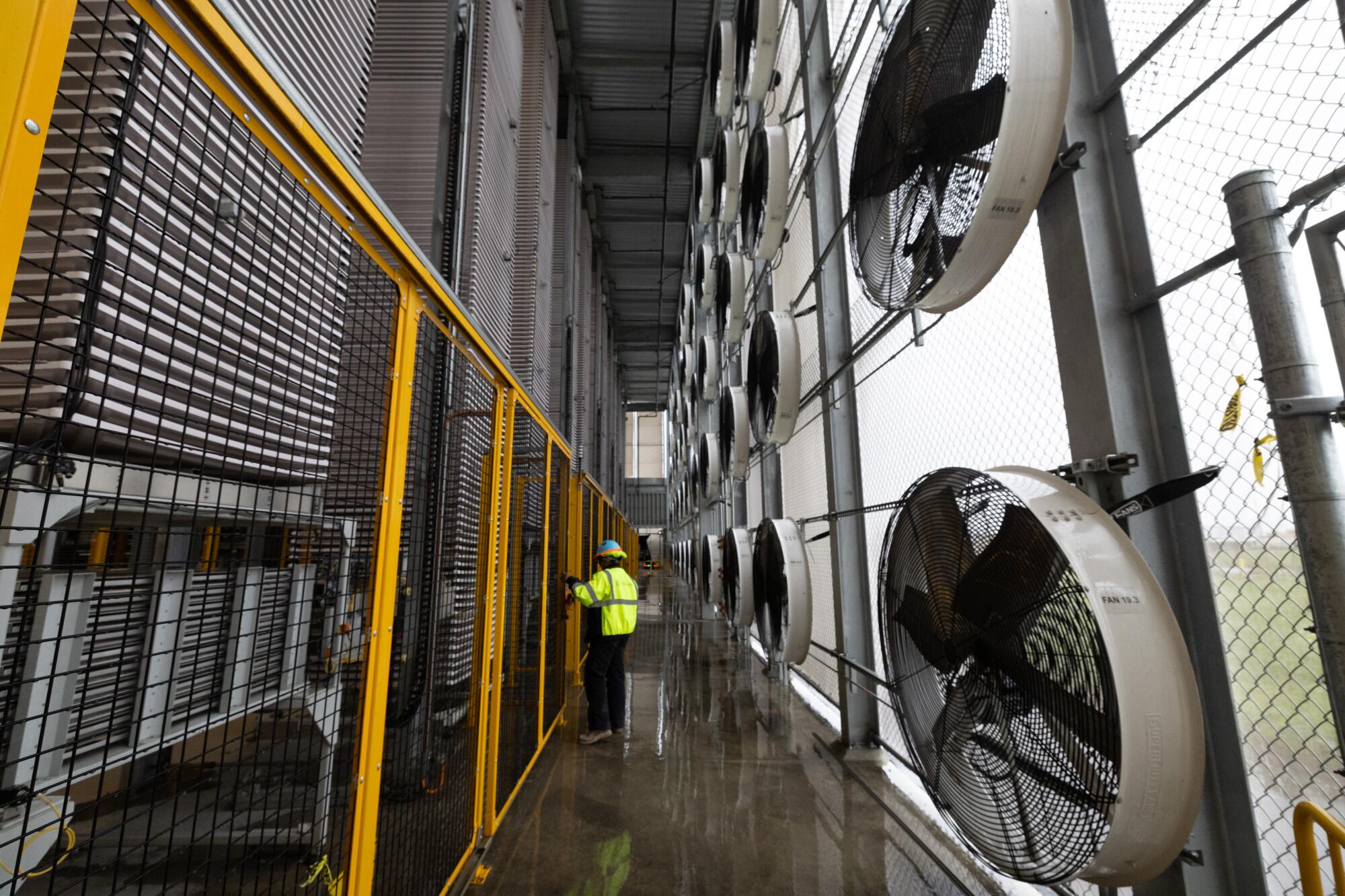 Des structures imposantes composées de ventilateurs et de plateaux capturent le dioxyde de carbone à l’intérieur d’une usine de captage direct de l’air.