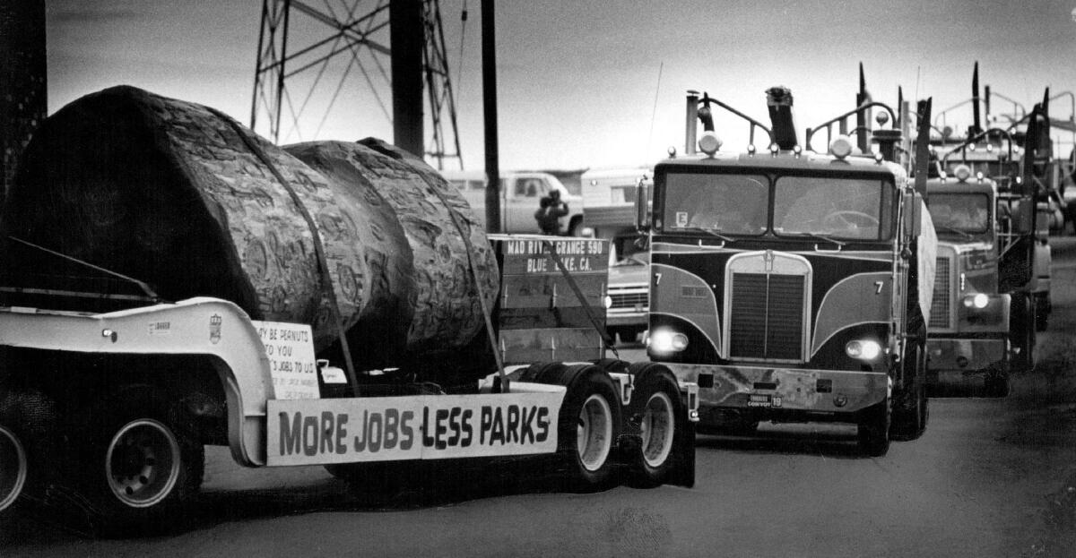 Un camion grumier porte une pancarte indiquant « plus d'emplois, moins de parcs ».