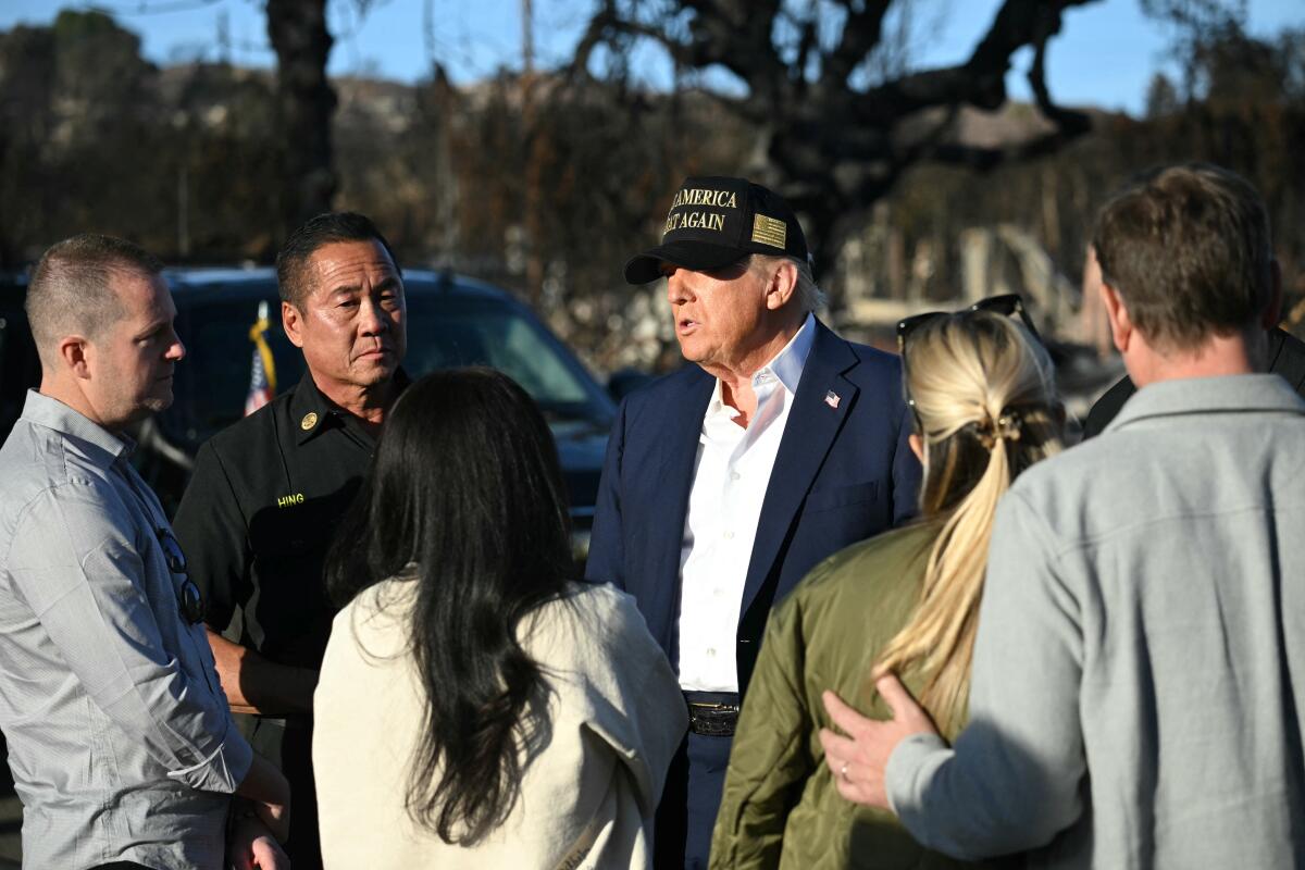 Vendredi, le président Trump parle avec les résidents et autres alors qu'il visitait une zone endommagée par le feu dans les palissades du Pacifique.