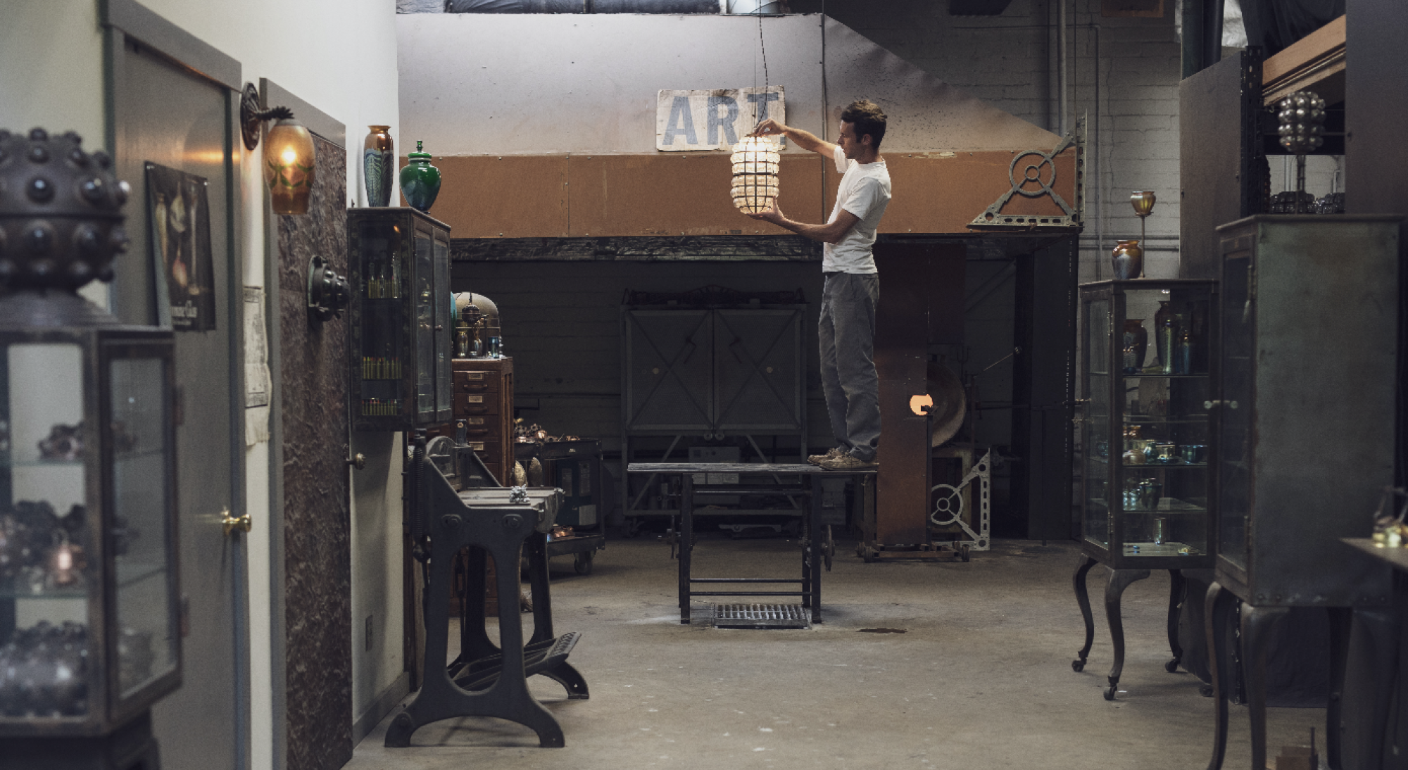 Evan Chambers tient un pendentif en verre dans son atelier.