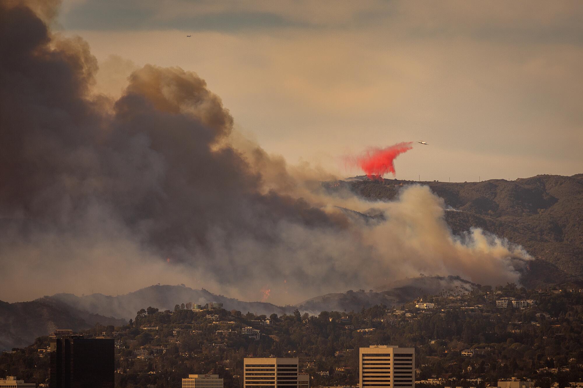 Un avion laisse tomber un ignifuge sur le feu des Palisades.
