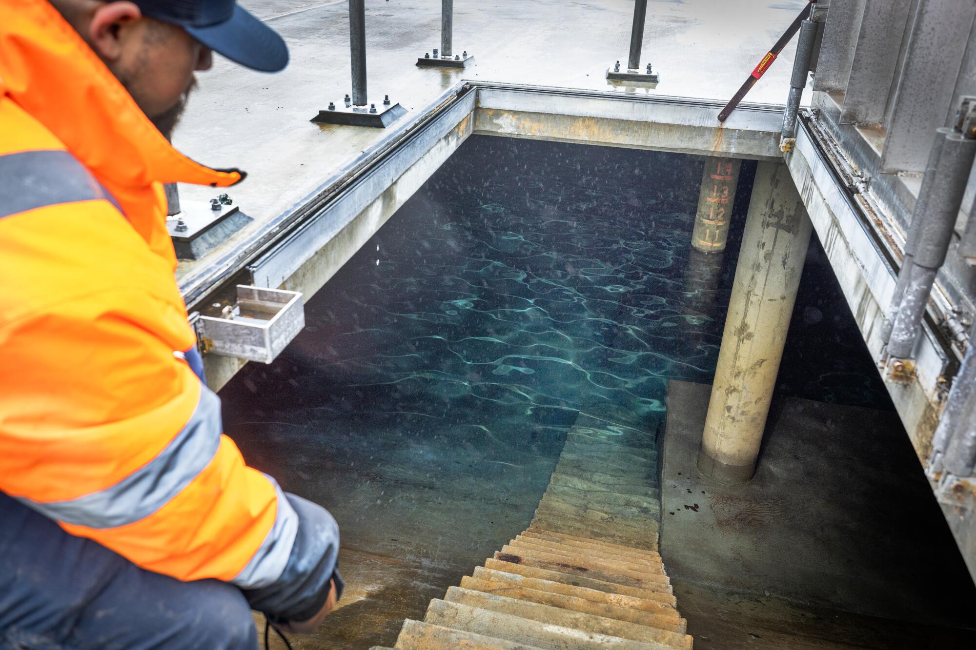 Un homme montre comment l'eau traverse le site du réservoir de Glenrose.