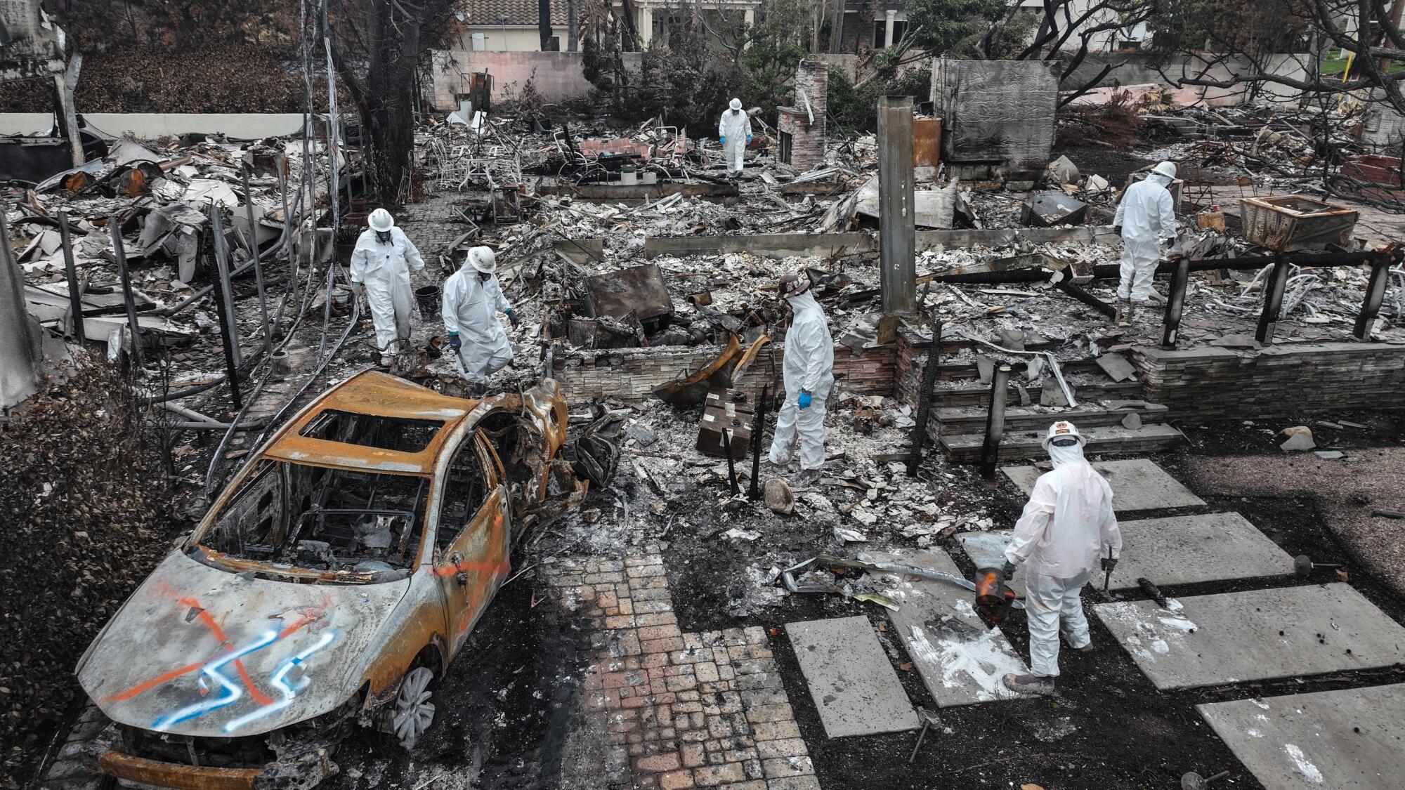 Les équipages de l'EPA peignent les ruines d'une maison brûlée