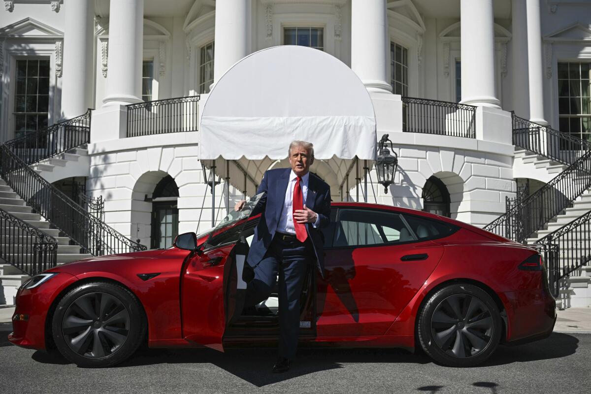 Donald Trump sortant d'un modèle rouge Tesla devant la Maison Blanche