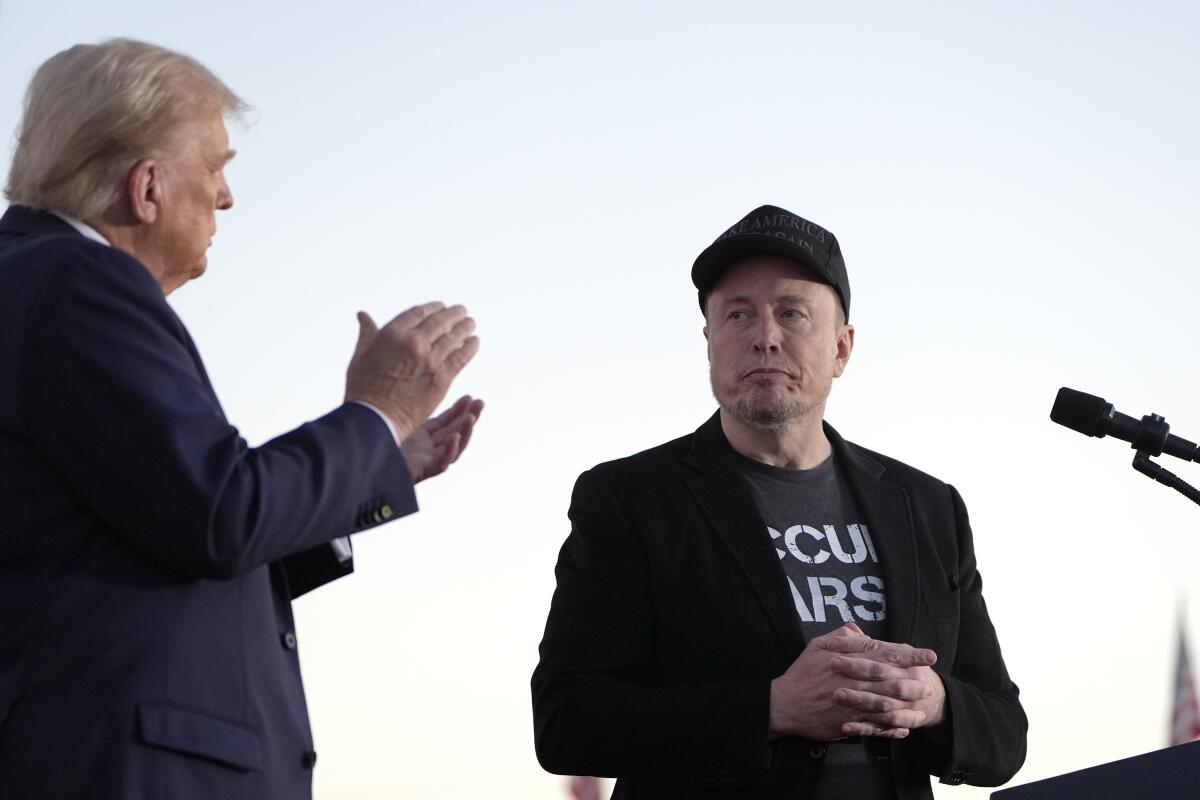 Le président Trump et Elon Musk se tiennent les uns à côté des autres près d'un prudente.
