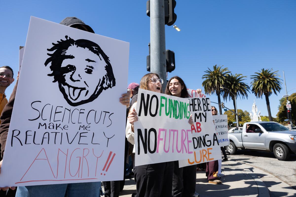 Les manifestants détiennent des pancartes dans un rallye scientifique debout à Westwood le 7 mars.