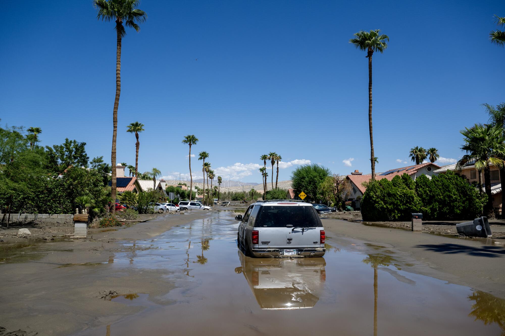 Un SUV est l'un des nombreux véhicules coincés encore coincés dans les eaux de boue et d'inondation après la tempête tropicale Hilary.