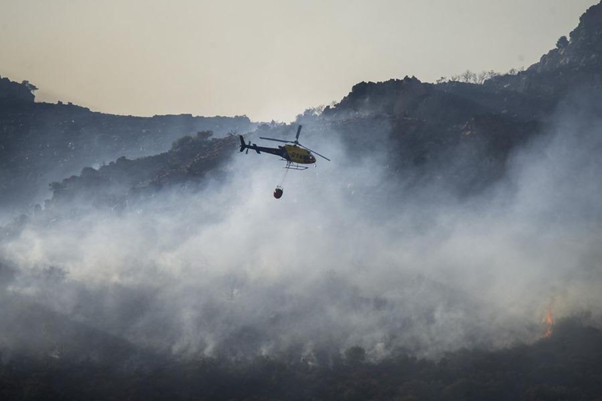 Un helicóptero trabaja sobre un incendio en la sierra de Malagón (ciudad réel).