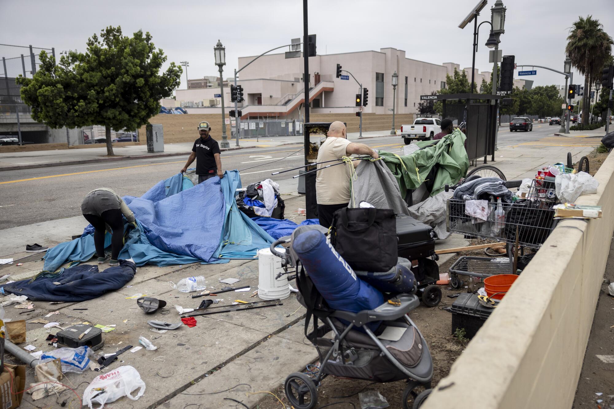 Les personnes qui éprouvent l'itinérance emballent leurs tentes et leurs effets personnels au centre-ville de Los Angeles.
