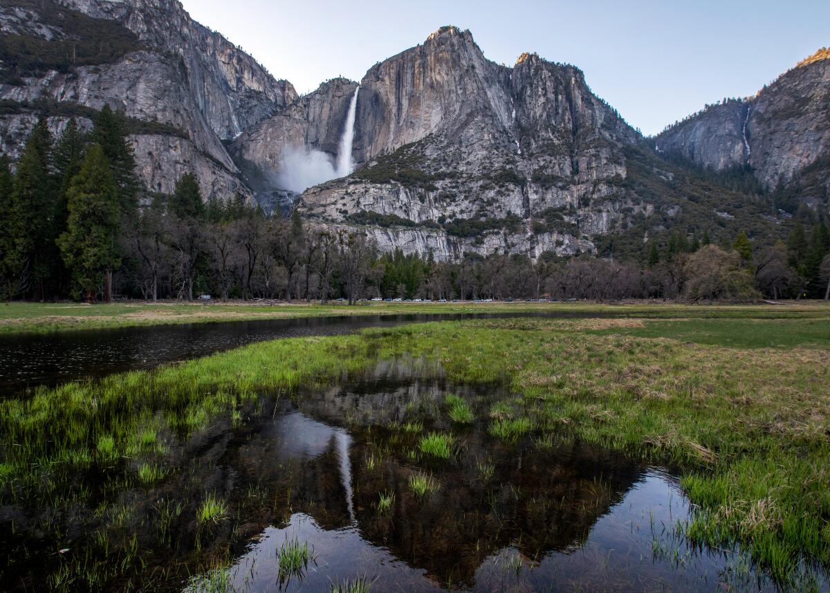 Une cascade se reflète dans l'eau dans la prairie dans la vallée de Yosemite alors que le manteau neigeux fond.
