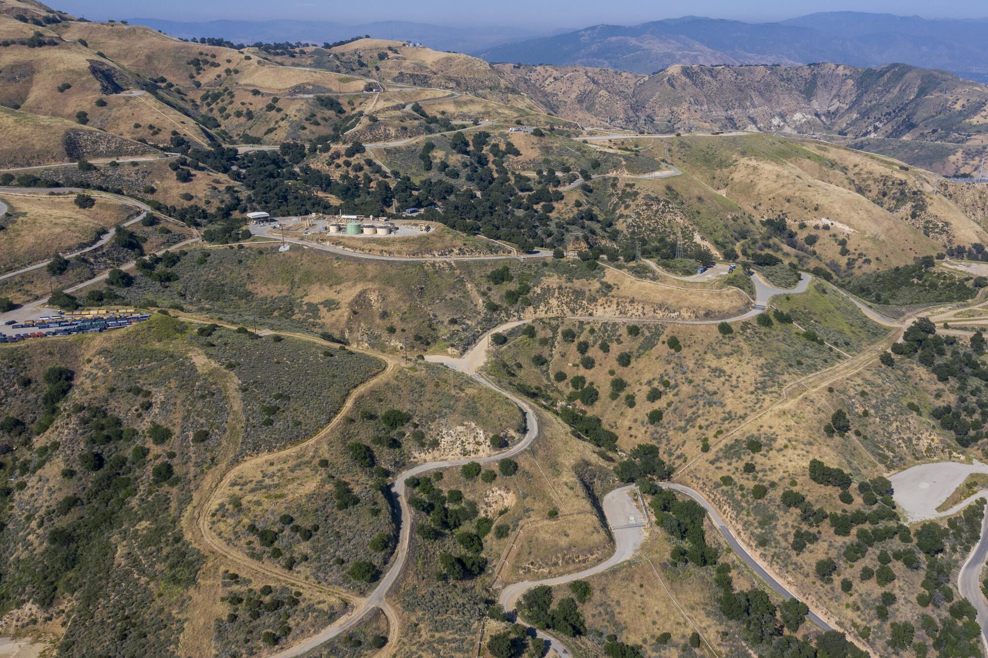 Vue d'une installation de stockage dans une région vallonnée avec des routes sinueuses 