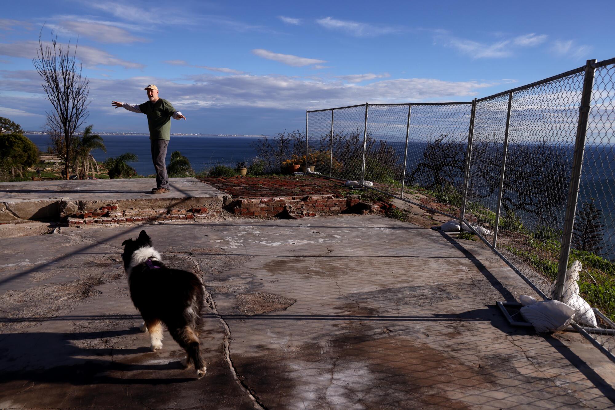 Kraig Hill et son chien Boudi se tiennent sur les fondations où la maison de Hill a été détruite dans l'incendie des Palisades. 