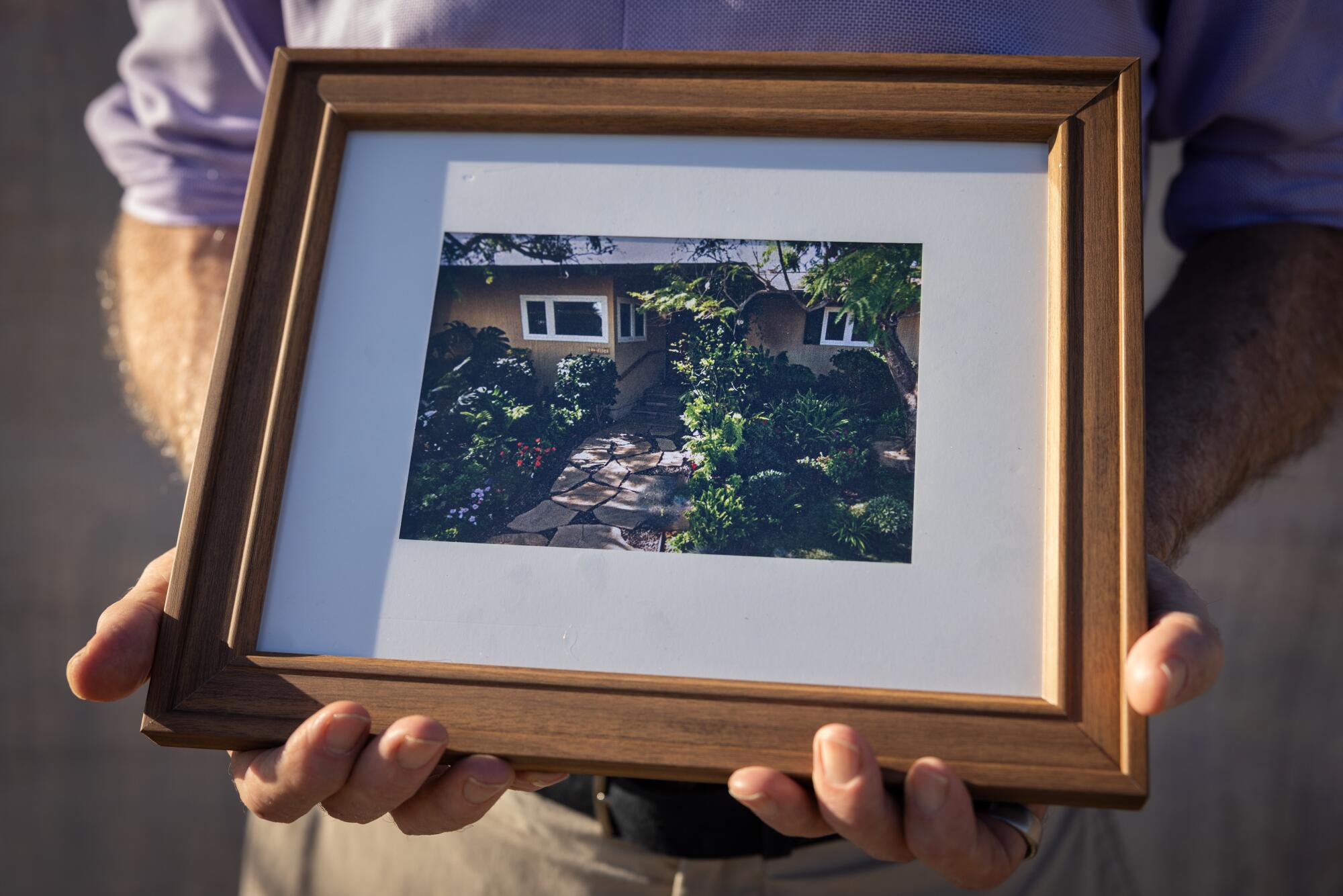 Robert Lempert tient une photo de sa maison avant qu'elle ne soit détruite par l'incendie des Palisades.