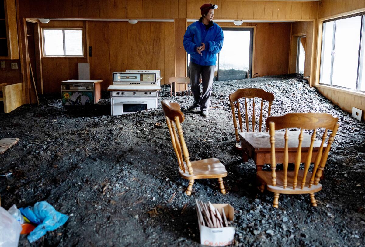 Misty Cheng examine les dégâts causés par les inondations dans sa maison à Wrightwood, en Californie, jeudi.