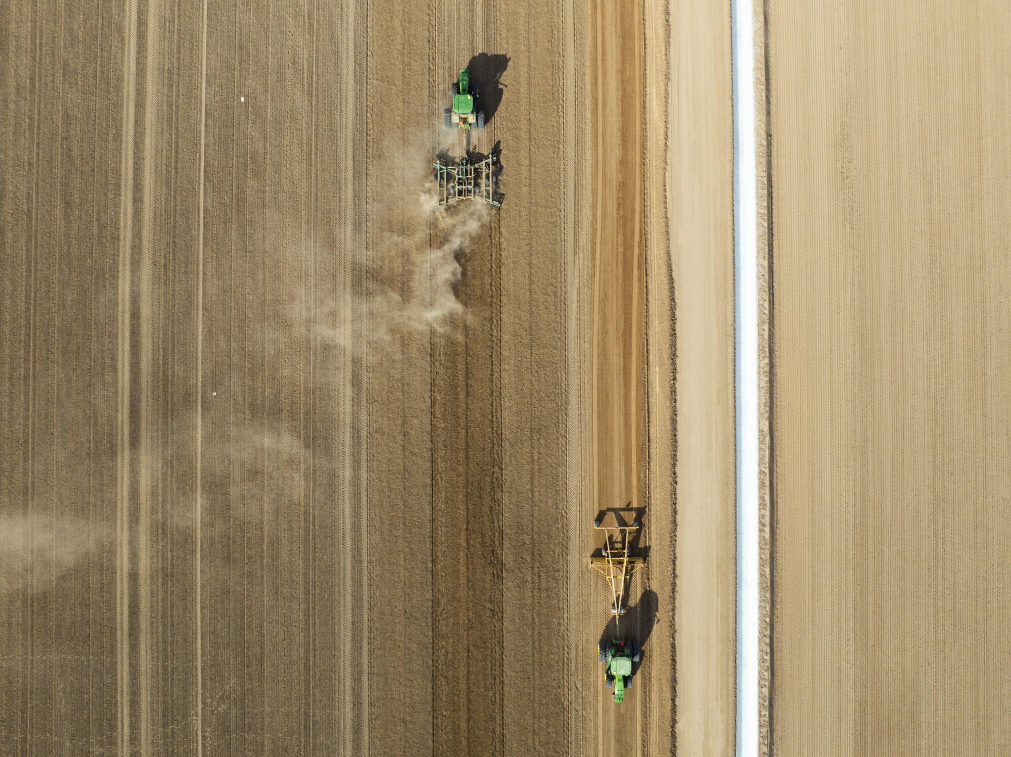 Des véhicules agricoles travaillent dans un champ de luzerne appartenant à la société Fondomonte, à Vicksburg, en Arizona.