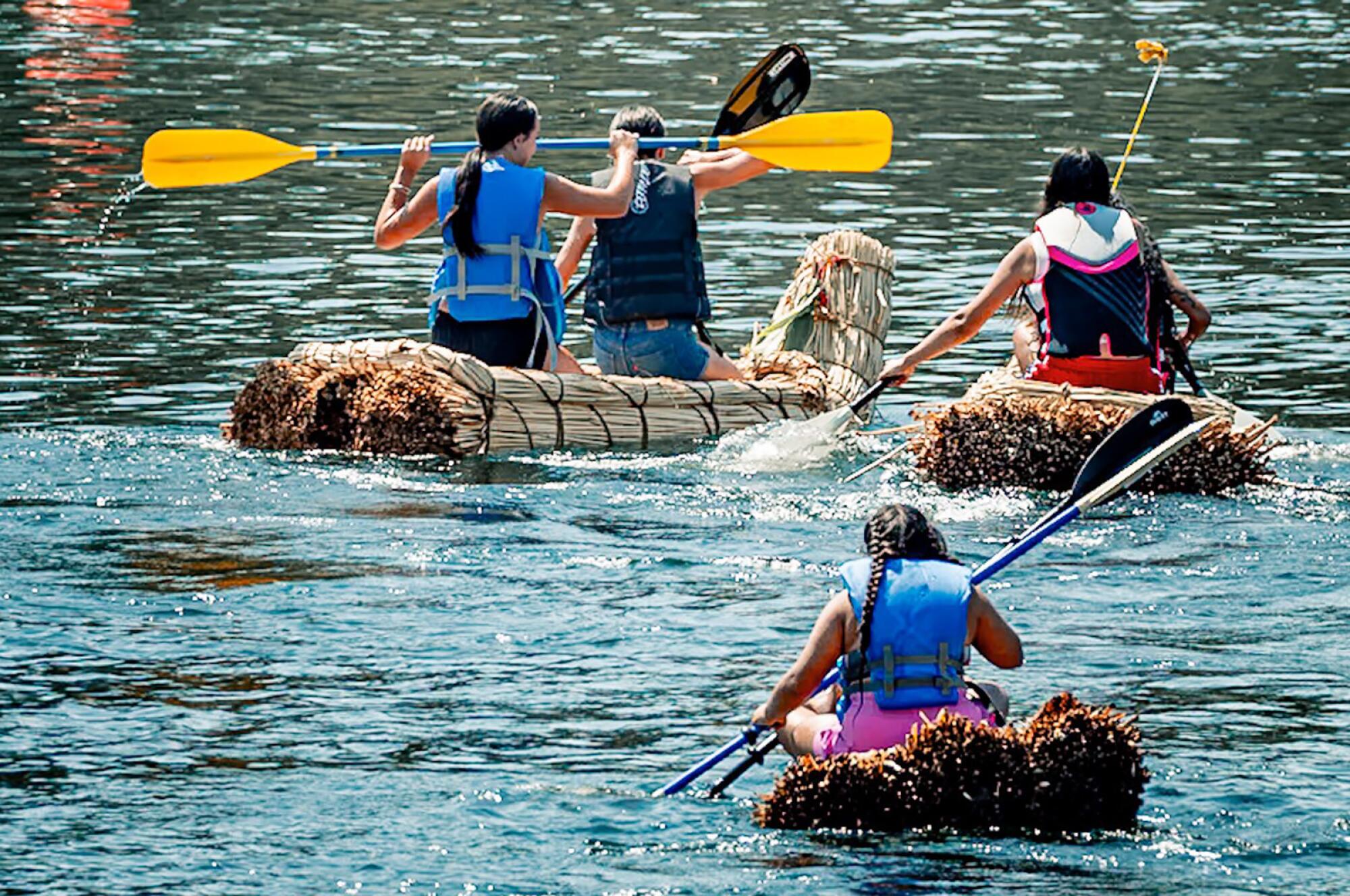 Membres de la tribu sur des bateaux Tule