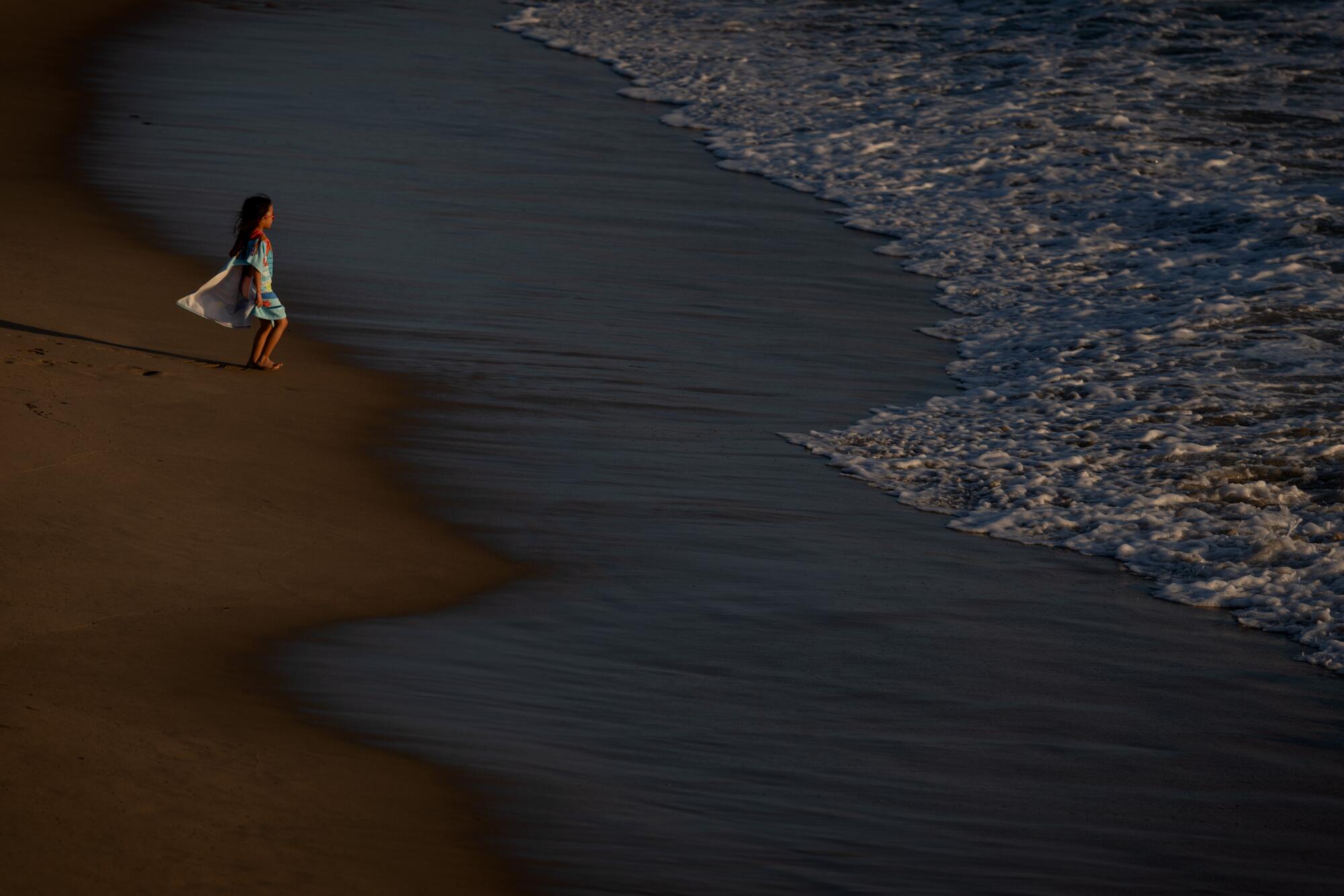 Une fille joue dans l’eau près de la jetée d’Hermosa Beach, où la température de l’eau était de 63°F. 