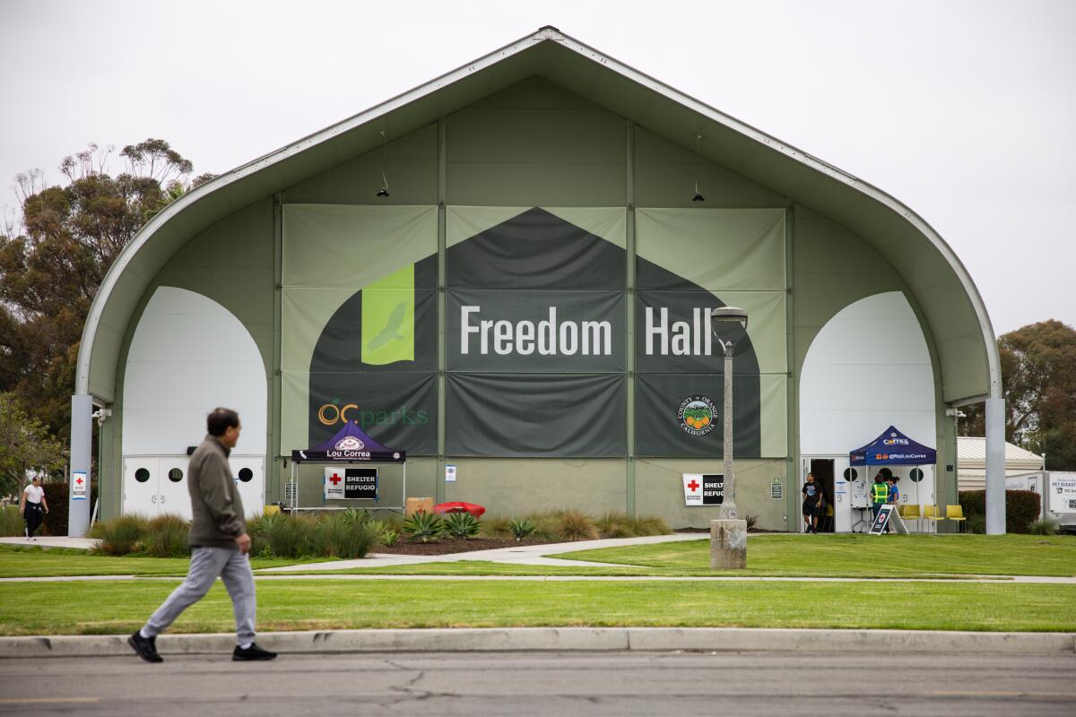 Un homme passe devant le refuge Freedom Hall dimanche à Garden Grove.