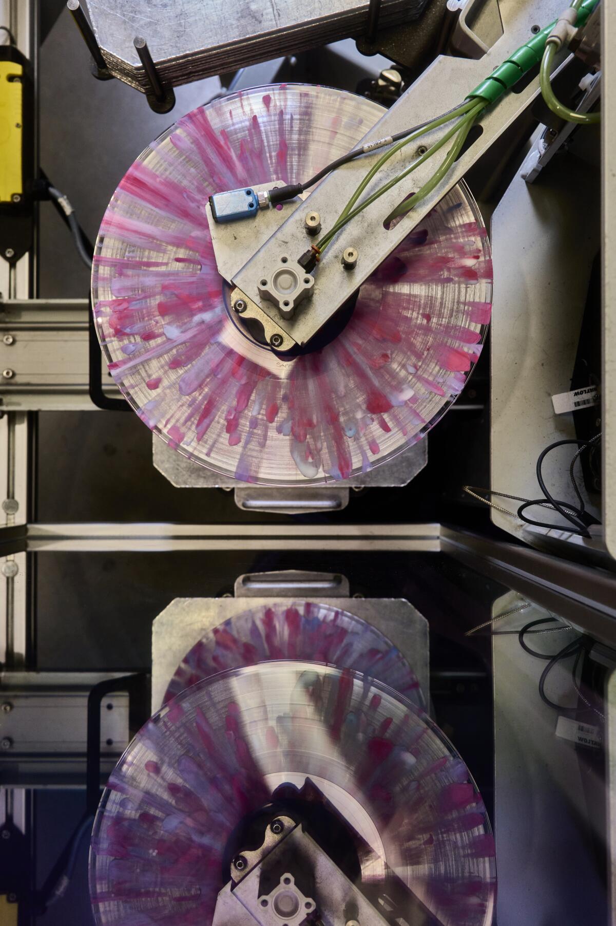 Des disques à motifs d'éclaboussures roses, violets et bleus sont en cours de préparation pour le découpage.