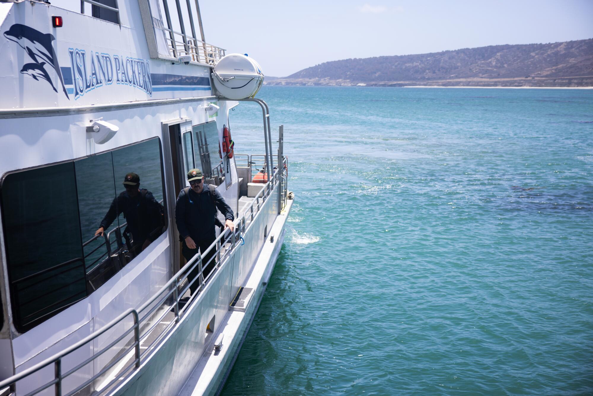 Un homme marche le long d’un ferry en mer.