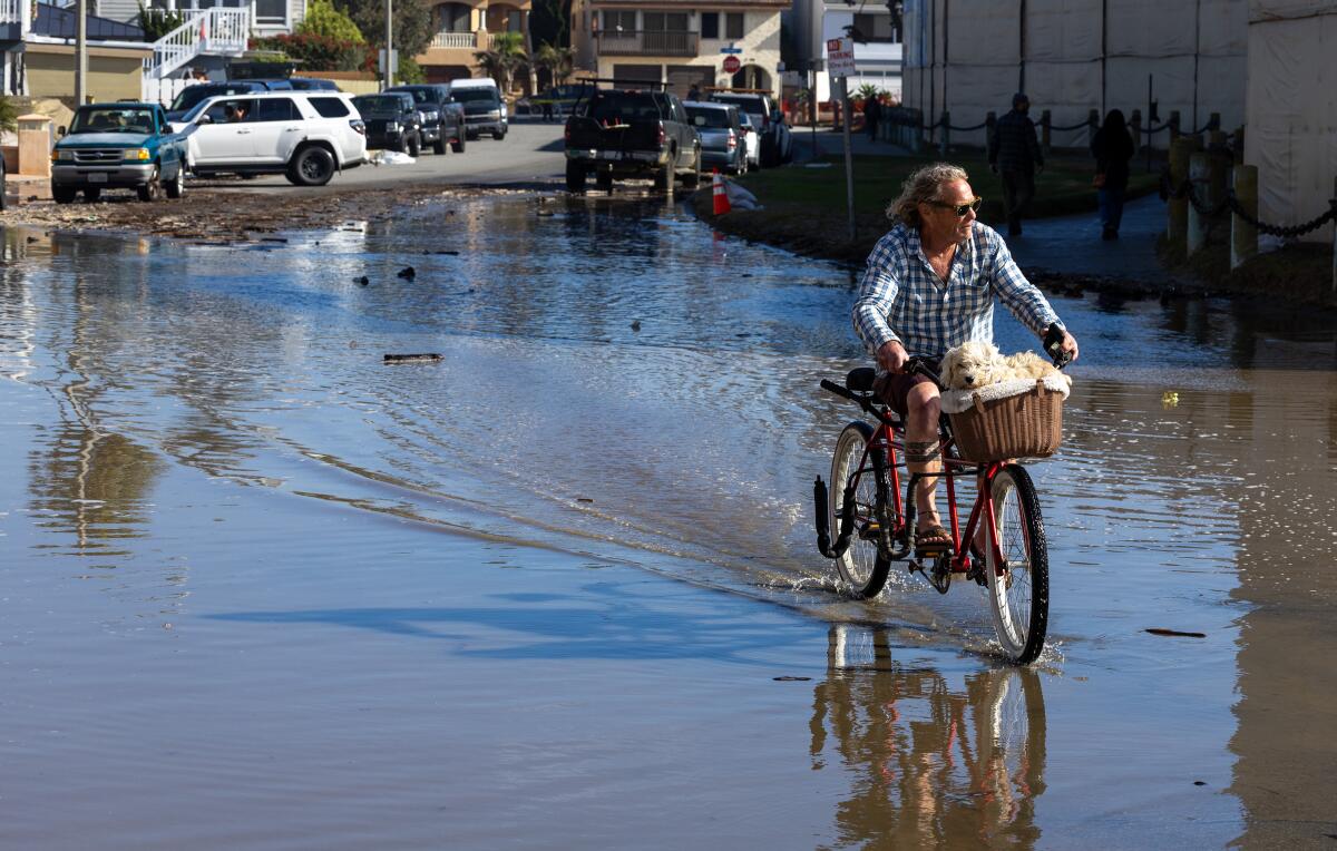 Homme à vélo traversant une route inondée 