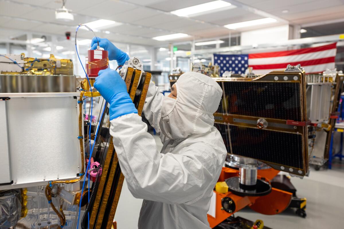 Un employé de Muon Space, basé à Mountain View, met la touche finale à un satellite de détection des incendies de forêt.