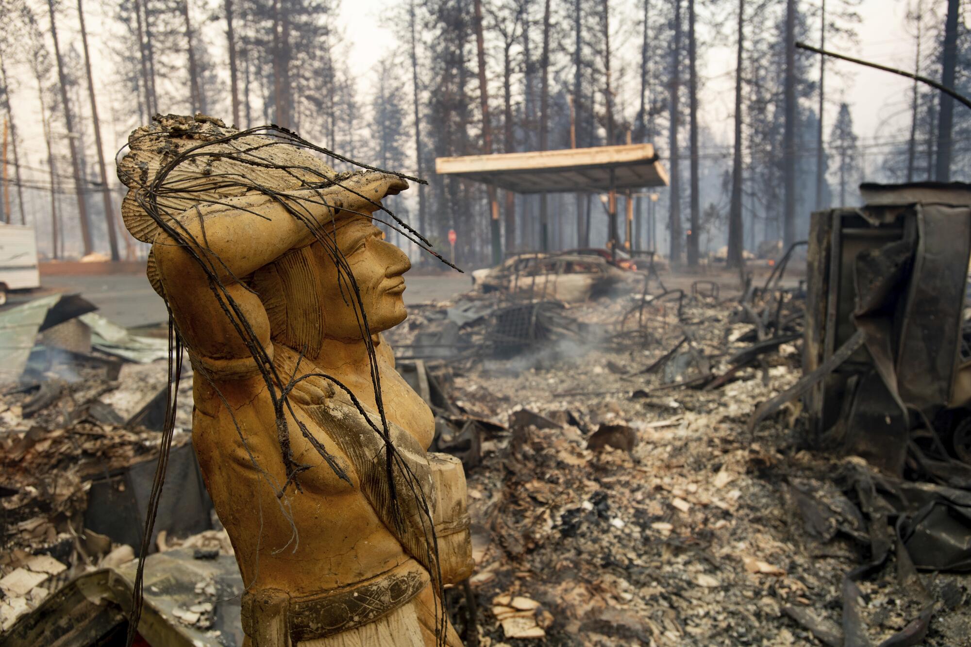 Une statue repose au milieu d'un terrain calciné 