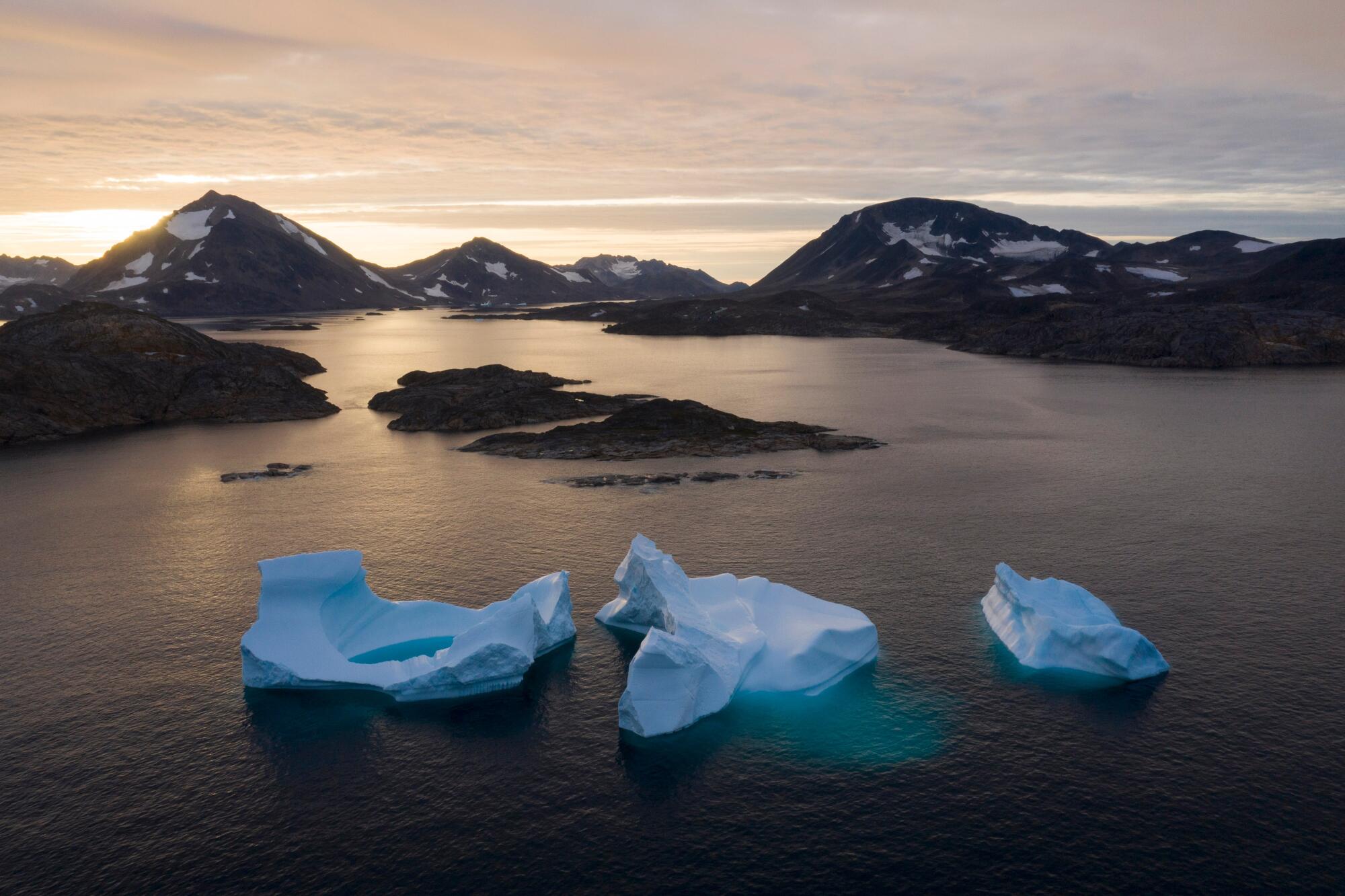 De gros icebergs s'éloignent alors que le soleil se lève près de Kulusuk, au Groenland, le 16 août 2019.