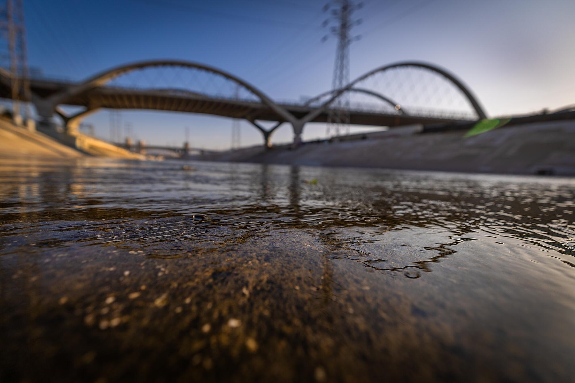 La rivière Los Angeles coule sous le pont de la Sixième rue au coucher du soleil