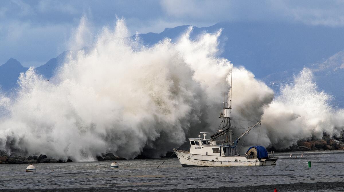 Une grande vague s'écrase sur les rochers, vue depuis la jetée de Redondo Beach