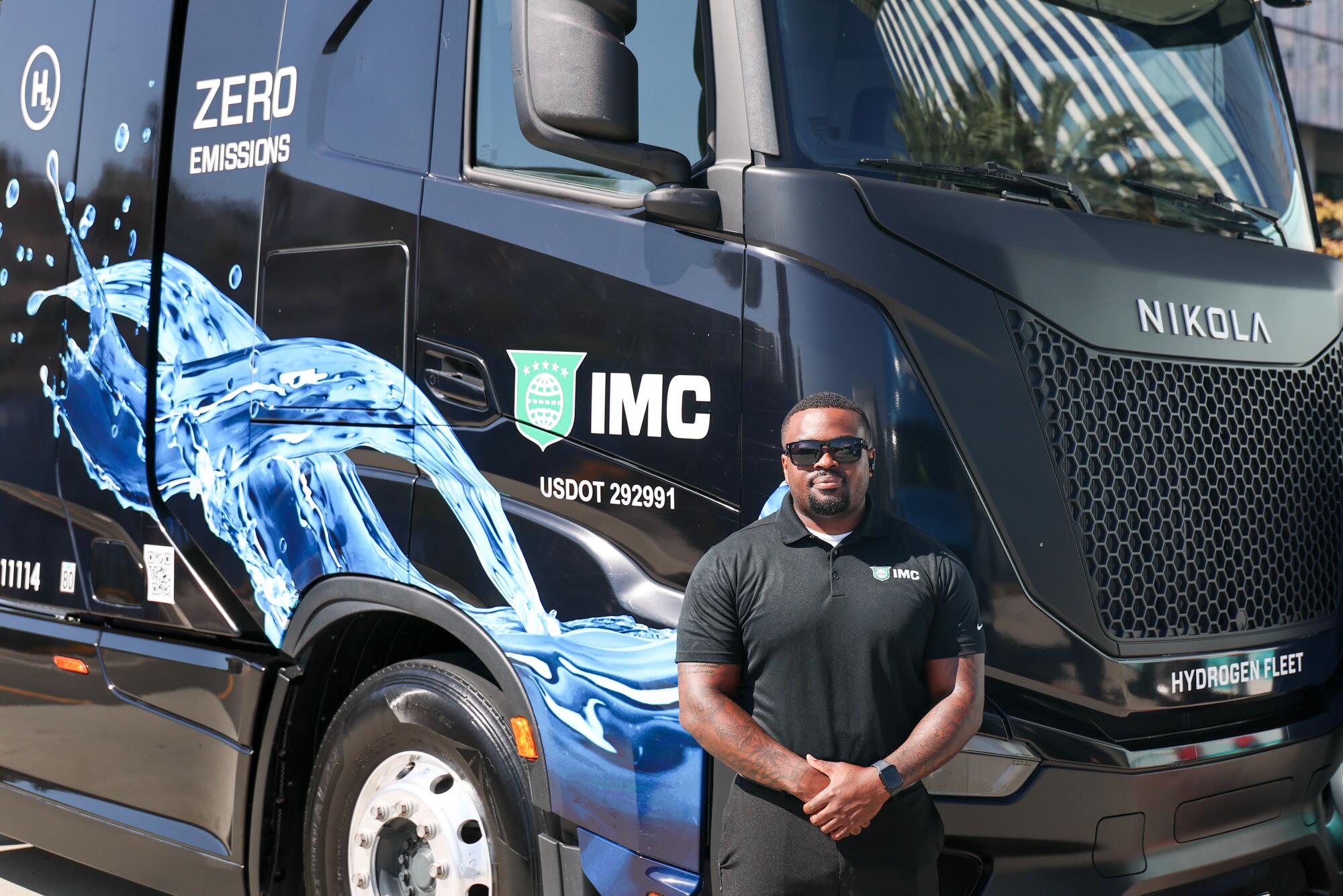 Un homme se tient à côté d’un semi-remorque Nikola hydrogène-électrique de classe 8.