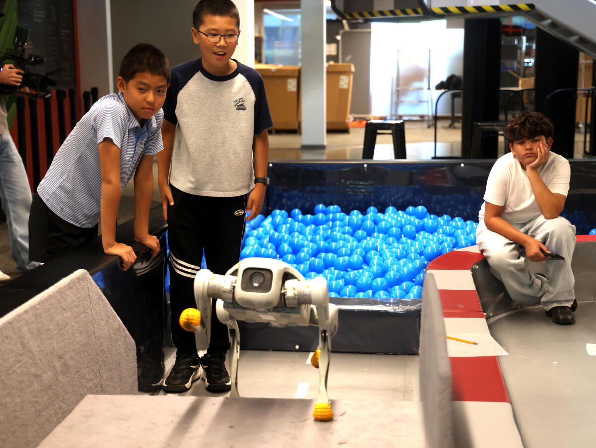 Les étudiants regardent leur robot programmé parcourir une course d'obstacles lors d'un camp d'été de robotique à Faraday Future.