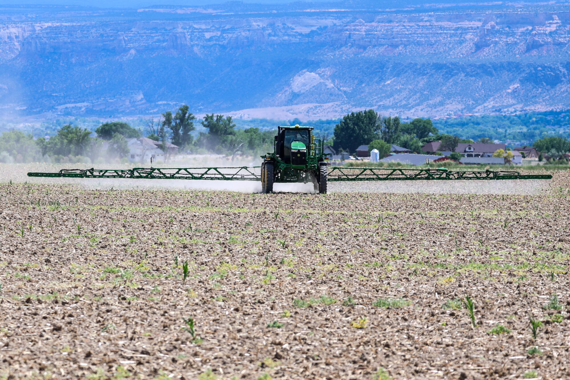 Un tracteur pulvérise un herbicide sur un champ.