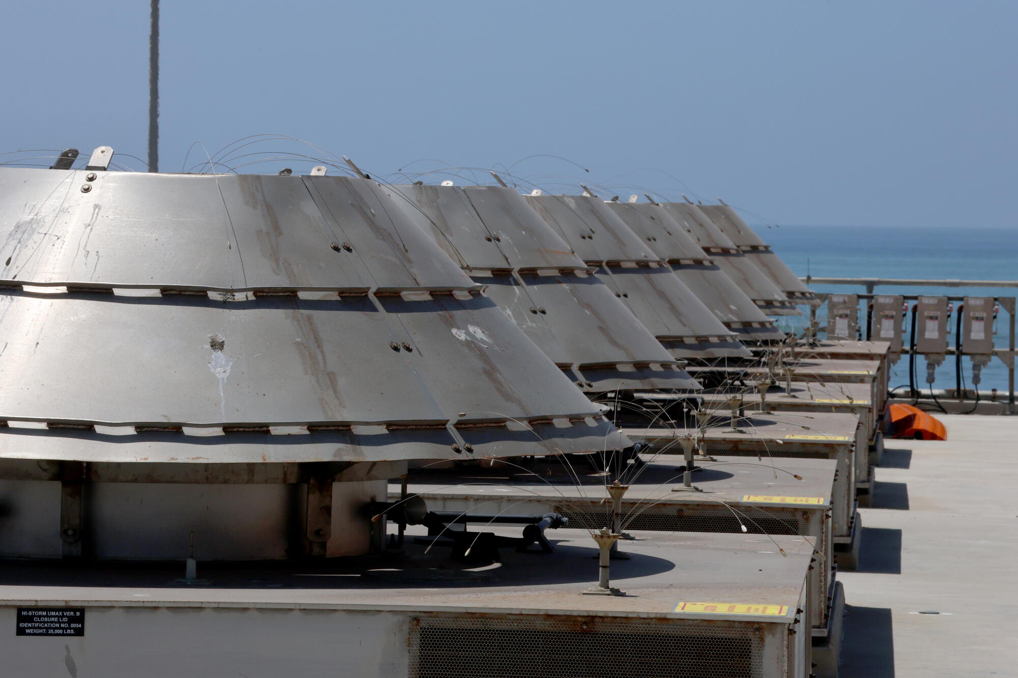 Rows of round concrete vaults, each holding a canister of used nuclear fuel.