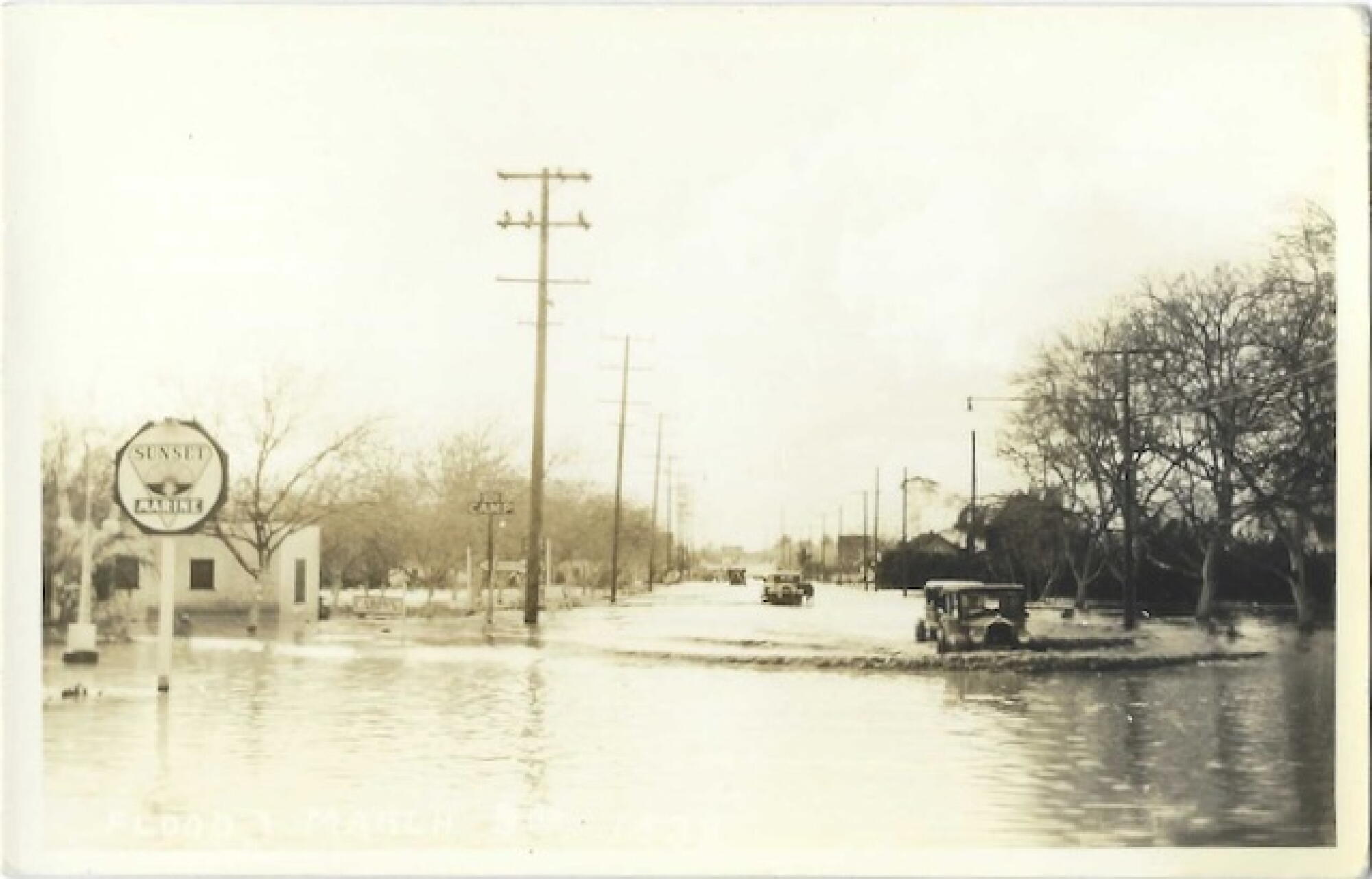 Les voitures font des vagues dans une rue inondée sur une carte postale vintage de ton sépia