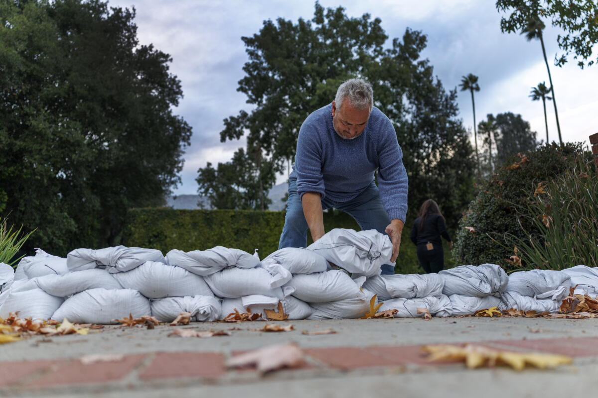 Bob Ganguin d'Altadena place des sacs de sable au bout de son allée.